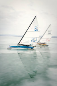Ice sailing European championship on Lake Balaton in Hungary, Two ice sailors high on the wind on their way to the turning point Ice sailing European championship on Lake Balaton in Hungary, Two ice sailors high on the wind on their way to the turning point